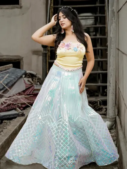 A three-quarter shot showing the model's pose and the iridescent quality of the skirt.
