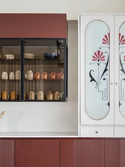 This custom crockery unit from the "Crimson Paradise" project is a work of art. The deep red cabinets are paired with a white unit featuring frosted glass doors with a beautiful, custom art deco-inspired motif.