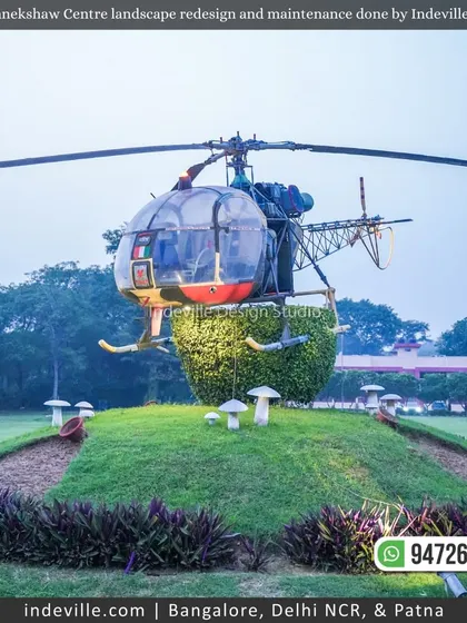 A unique landscape feature at Manekshaw Centre: a helicopter installation on a manicured green mound. My work involves creating and maintaining such unique landscape elements.
