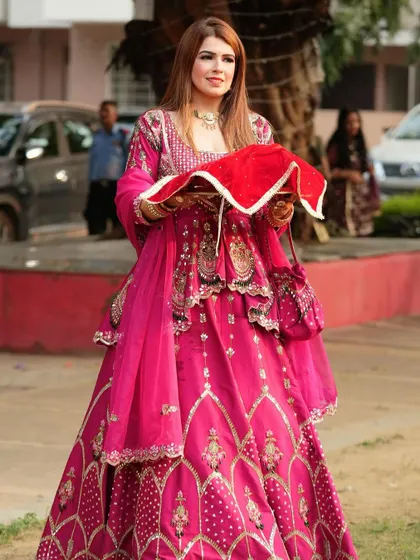 A full-length view of the client in her Karwa Chauth attire. The mehendi is an important part of the overall festive look.