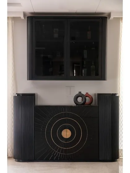This bold, black bar unit is a true statement piece. We designed it with a sunburst pattern on the doors, intricate fluting, and brass details, creating a sophisticated spot for entertaining.