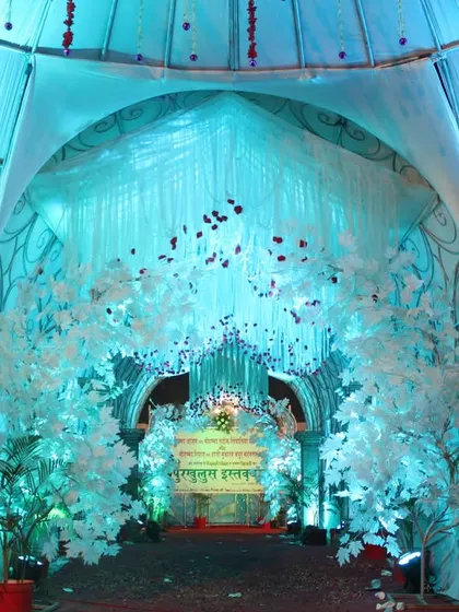 The entrance to a wedding, beautifully lit in aqua blue, with a digital screen displaying the couple's names.