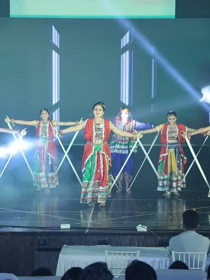The full group in a synchronized formation during the dandiya folk dance performance.