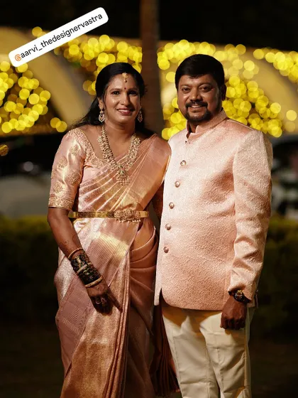The proud parents of the bride, twinning in elegant pastel pink outfits that I custom designed for them.