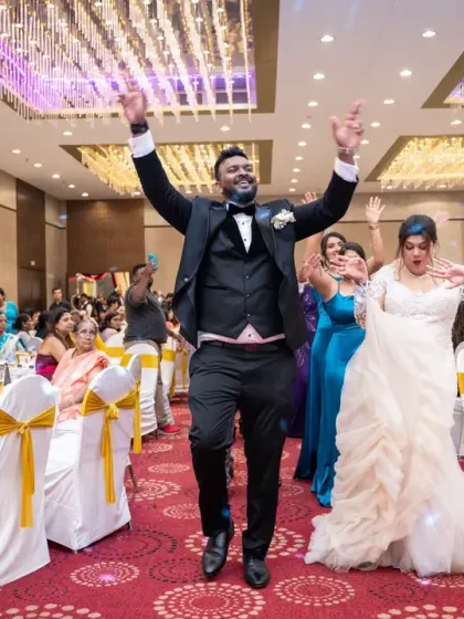 Jumping for joy! The couple's enthusiastic entrance sets the tone for a fun-filled reception party.