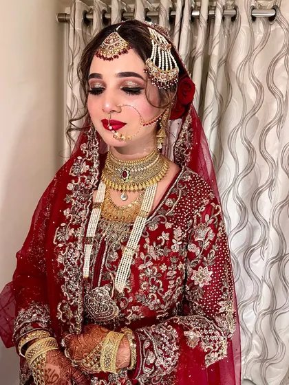 A detailed shot of our best-ever Nikah look. The intricate gold jewelry and the rich red outfit are perfectly complemented by the classic makeup.