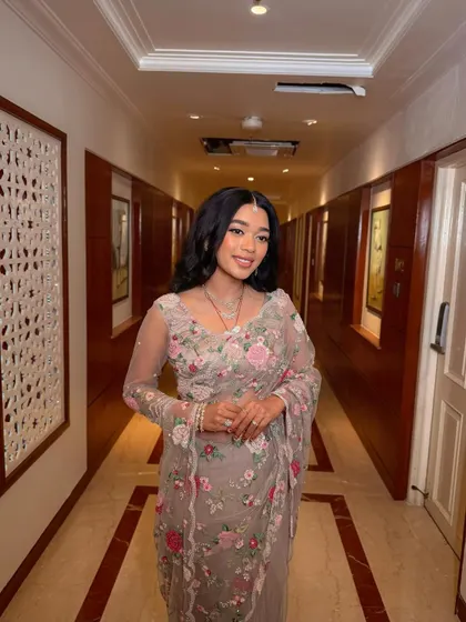 A full-length shot of the "flower girl" bride in her gorgeous floral saree. The soft glam makeup enhances her natural beauty and completes the romantic look.