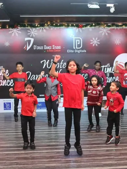 The entire group of kids jumping for joy during their Christmas dance showcase.