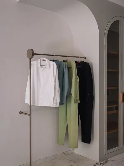 A detail of the minimalist, freestanding clothing rack, which adds to the boutique-like feel of the walk-in wardrobe.