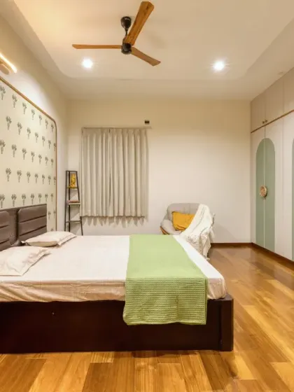 The parents' bedroom is designed for comfort and warmth, with a soothing sage green and white color palette on the arched wardrobes.