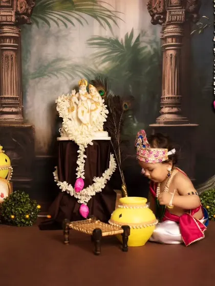 A quiet, devotional moment as our little Krishna bows his head towards the makhan pot.