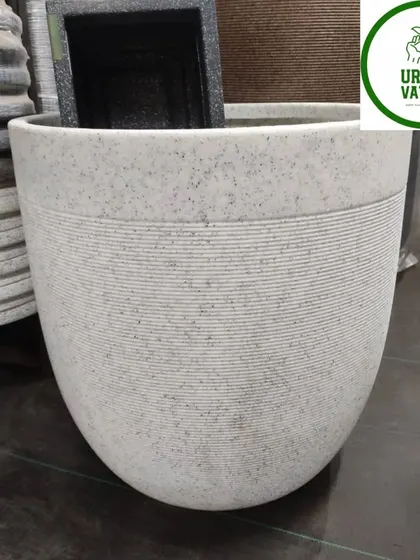A large, white, round fiber pot with a line texture.