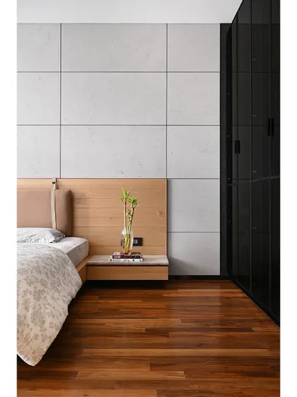 A floating bedside table and a sleek black wardrobe with glass shutters complete the room's modern, masculine aesthetic.