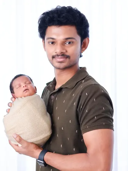 A proud father holds his sleeping newborn. These simple, clean portraits against a white background are timeless.