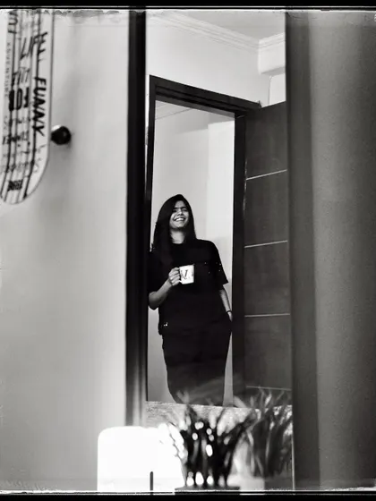 Vasu, enjoying a cup of coffee in her doorway. A simple, everyday moment that feels peaceful and content.