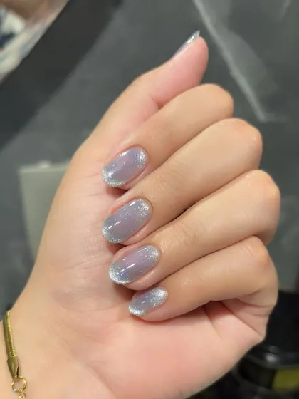 A subtle cat eye effect with a glittery finish on short, natural nails.