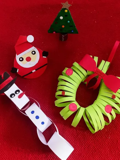 An assortment of Christmas crafts, including a paper chain snowman, a wreath, and Santa Claus. Each child gets to create their own festive decorations to celebrate the season.