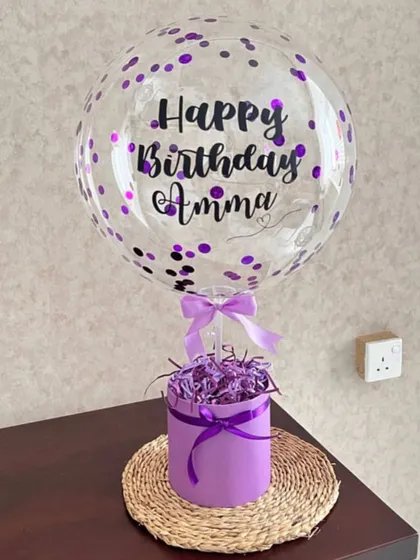 A simple yet striking hamper for Amma. This design uses a bold purple color scheme, with a confetti-filled balloon and a matching box filled with shredded paper, ready for you to add your own gifts.