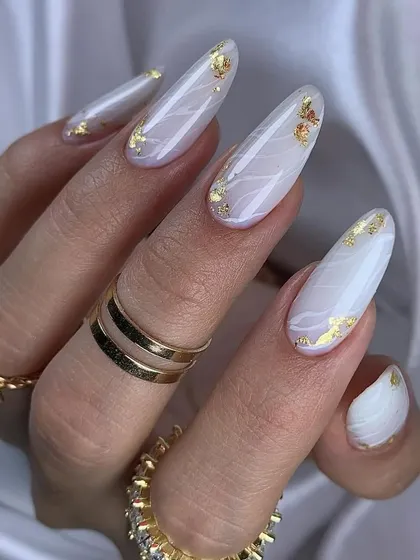 A close-up view of our white marble and gold foil nail art, showcasing the delicate lines and luxurious texture on long, elegant almond-shaped nails.