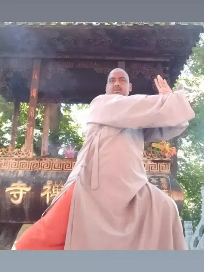 A powerful martial arts stance in front of a traditional incense burner at a temple in China. This pose demonstrates the stability and rootedness we develop through Shaolin training.