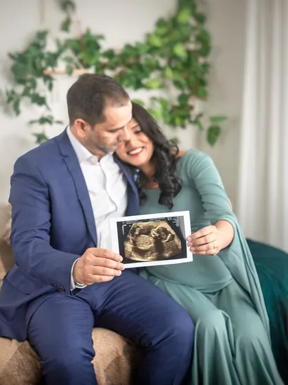 An expecting couple holds a sonogram picture, their first glimpse of their baby. This is a classic and meaningful shot for any maternity session, celebrating the beginning of their journey.
