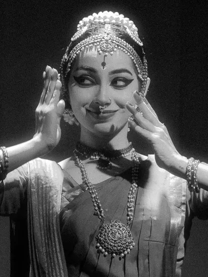 A close-up, black and white shot from a group performance, capturing a moment of shared expression and connection between the artists.