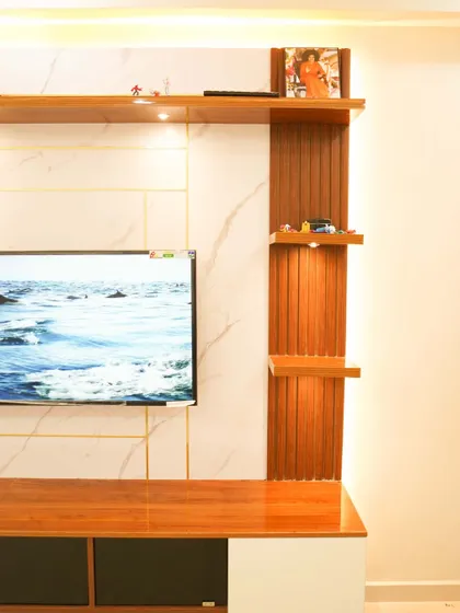 A close-up of the TV unit, highlighting the beautiful grain of the wood and the subtle veining of the marble panel. The warm backlighting enhances the textures.