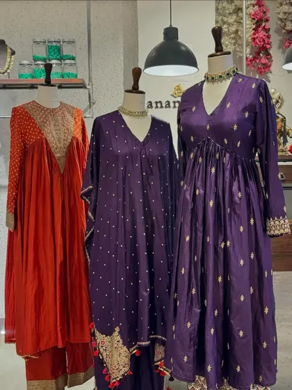 A vibrant collection of festive suits in orange and purple. The flowing silhouettes and delicate embellishments make these outfits both comfortable and stylish.