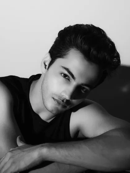 A slightly more stylized black and white headshot, using shadow to create a sense of character and intrigue.