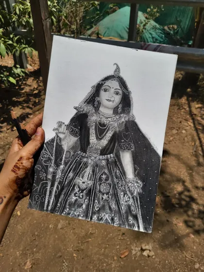 A hand-held shot of my completed Radha Rani portrait, showcasing the fine details achieved with graphite pencils on high-quality paper.