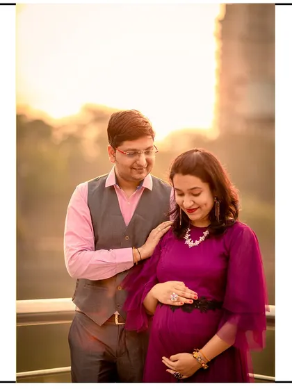A beautiful golden hour shot of a couple on a balcony, capturing a warm and intimate moment.