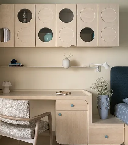 The son's bedroom in the Soft Serve apartment, designed with a focus on 'Seijaku' or tranquil stillness. The space features a built-in desk and overhead storage with playful circular cutouts.