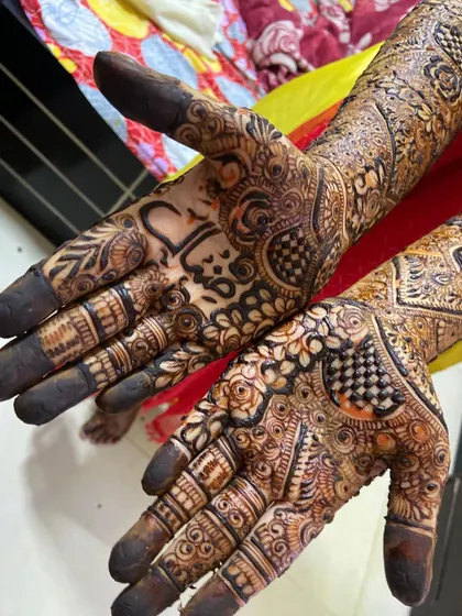 A close-up of a bridal palm with the couple's names beautifully integrated into the design.