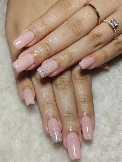 A classic set of square-shaped nude pink extensions. The single silver glitter accent nail on the ring finger adds just the right amount of sparkle for a touch of glam.
