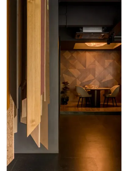 A detail shot showing the hanging veneer samples and the view into the discussion area, highlighting the layered design of the space.