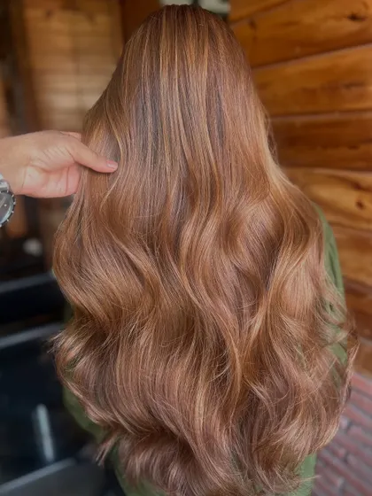 I love the warmth and dimension in this look. We combined a soft global base colour with delicate highlights to create this rich, caramel-toned result, finished with bouncy waves to show off the colour variation.