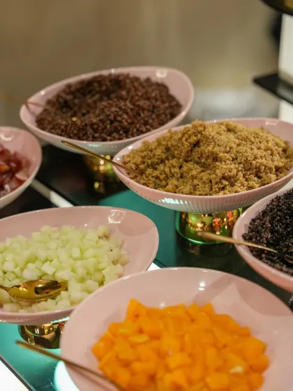 A DIY salad bar with various grains like quinoa and a selection of chopped vegetables and fruits. This allows guests to create their own healthy and delicious salads.
