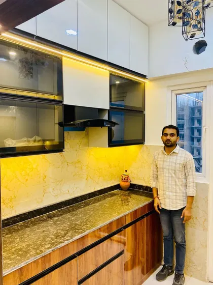 Me with the finished kitchen, which features a beautiful yellow-gold marble backsplash.