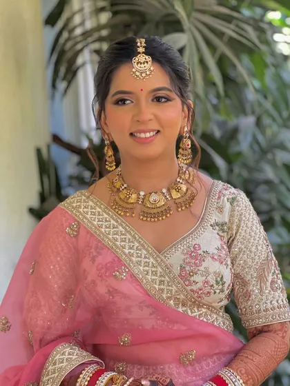 A happy portrait of the bride, her floral updo completing her pretty in pink look.