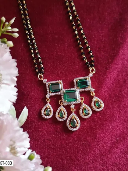 A statement mangalsutra with a pendant featuring large green stones. This piece is perfect for those who want a modern mangalsutra that is also bold and eye-catching.