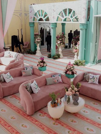A lounge area with modern, curved pink sofas. The mix of contemporary furniture with the romantic, vintage-inspired decor creates a fresh and stylish look.