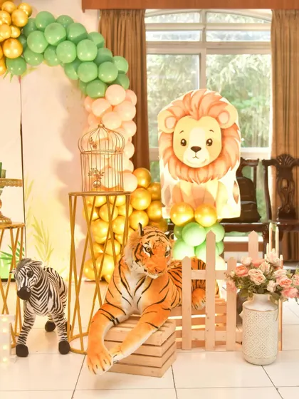 Detail shot of the jungle decor, showing a plush tiger and zebra next to a golden birdcage prop.