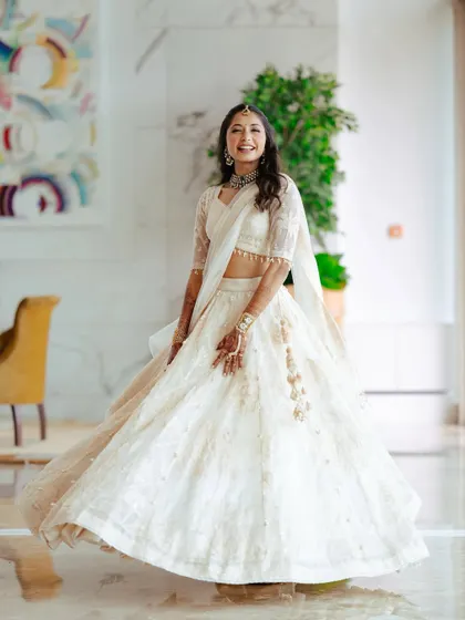 A joyful twirl in her gorgeous ivory lehenga. The movement shows how light and comfortable the makeup is, allowing for spontaneous, happy moments.