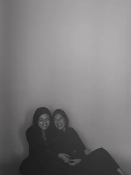 A soft, grainy photo of two friends sharing a laugh. This image feels like a cherished memory, a testament to the warmth of their bond.