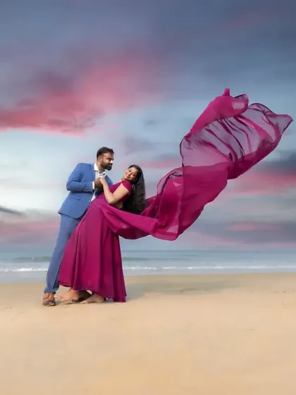 A dynamic and playful pre-wedding photo on the beach. The movement of the fabric and the couple's pose create a feeling of dance and celebration.