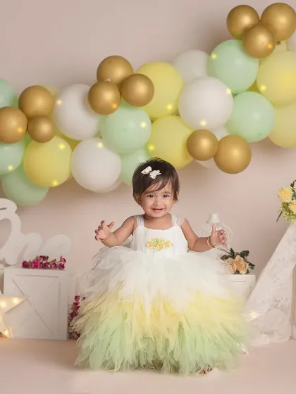 This happy little girl is all smiles as she celebrates turning one in her beautiful layered dress.
