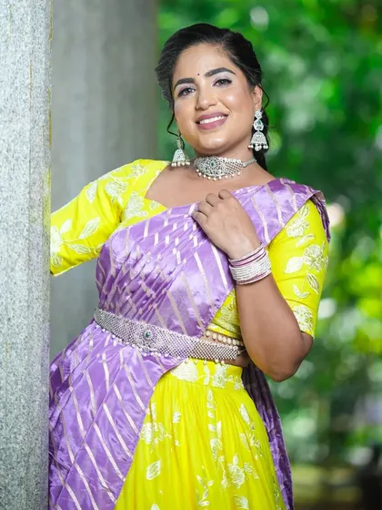 This client is all smiles in her custom yellow and purple half saree.