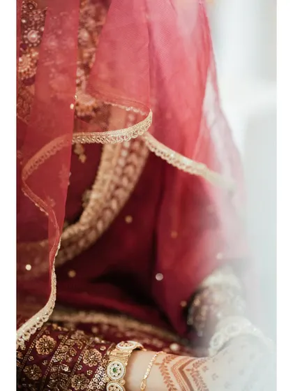 A detail shot of the bride's red lehenga and henna, capturing the beauty and tradition in a soft, artistic way.