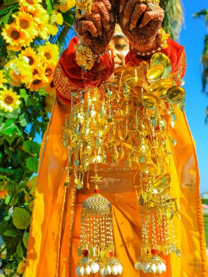 A close-up shot of the bride's chooda and kalire ceremony during her Haldi, set against a backdrop of vibrant sunflowers.