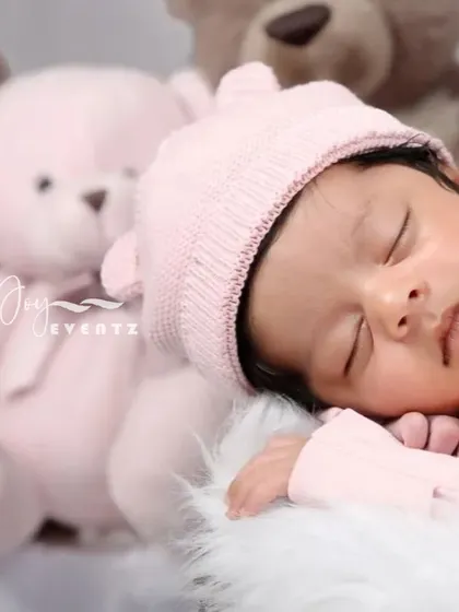 A soft and cuddly teddy bear theme is a classic choice for a newborn girl's photoshoot. The baby, wearing a pink bear-eared hat, sleeps peacefully next to a plush pink teddy bear.